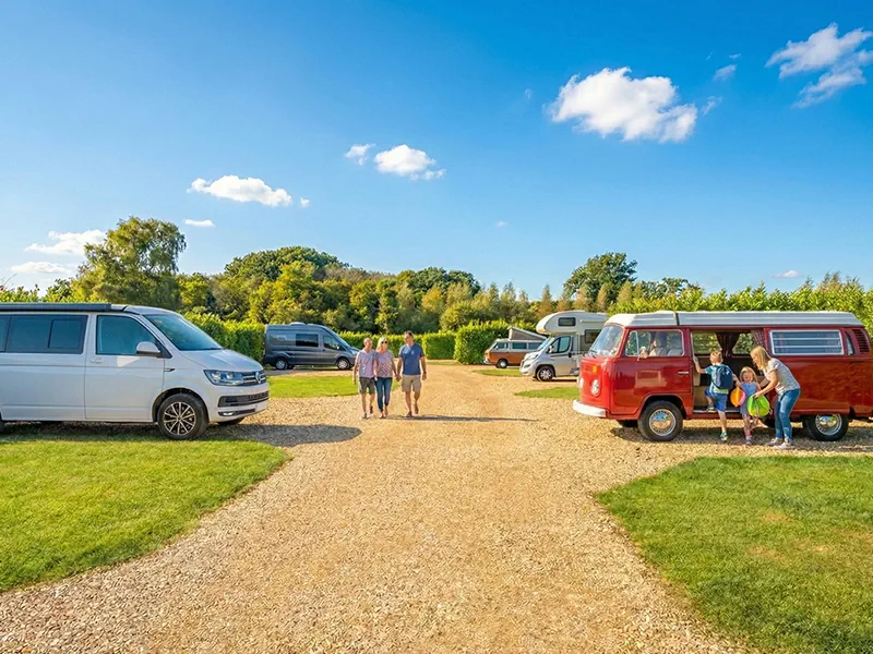 Children playing at family-friendly campervan site South Lytchett Manor Dorset with classic and contemporary vehicles
