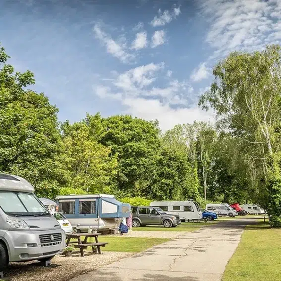Couple relaxing at motorhome pitch South Lytchett Manor touring park Poole Dorset