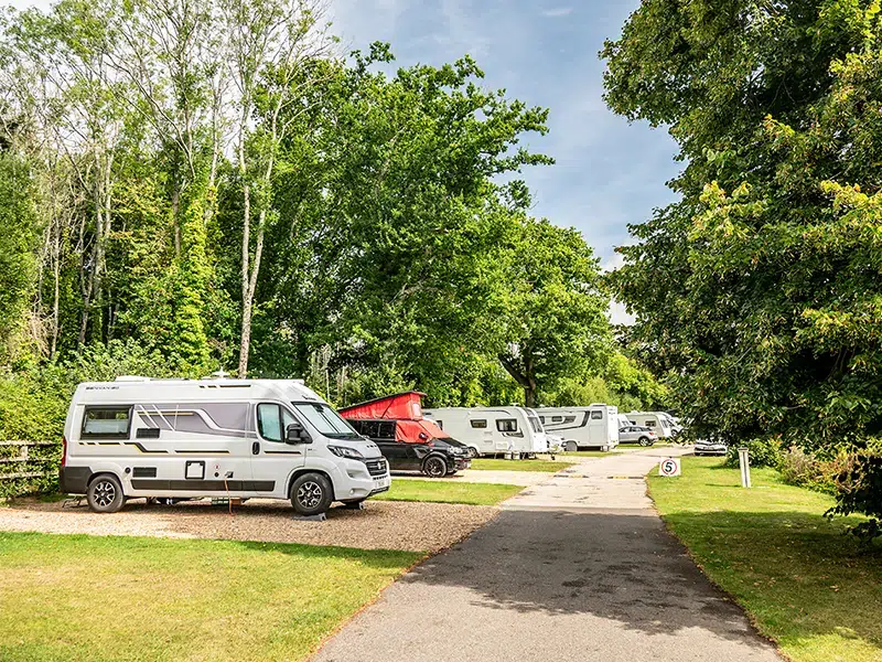 Couple relaxing at motorhome pitch South Lytchett Manor touring park Poole Dorset