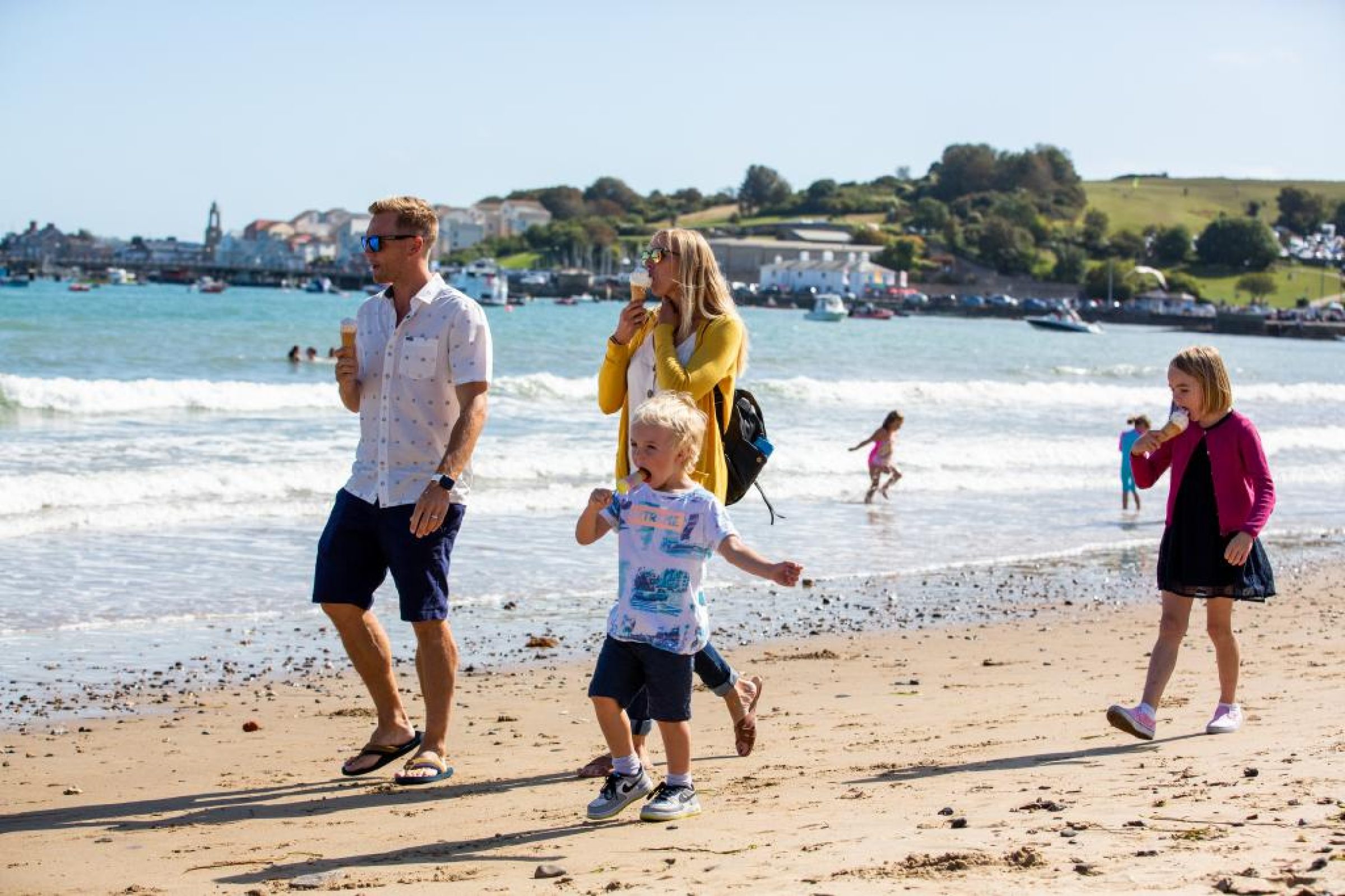 Family enjoying ice creams and a stroll along the beach