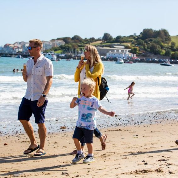 Family enjoying ice creams and a stroll along the beach